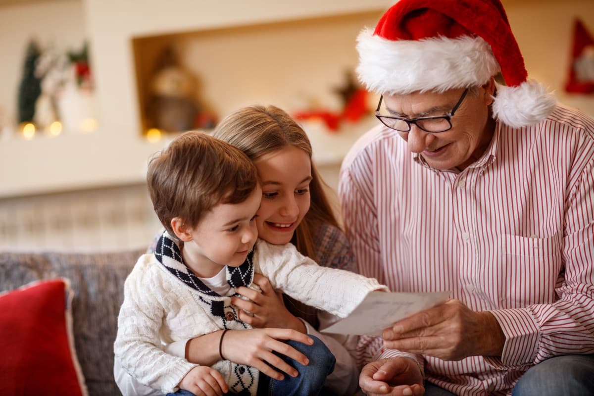 Happy grandad with grandchildren at Christmas celebration