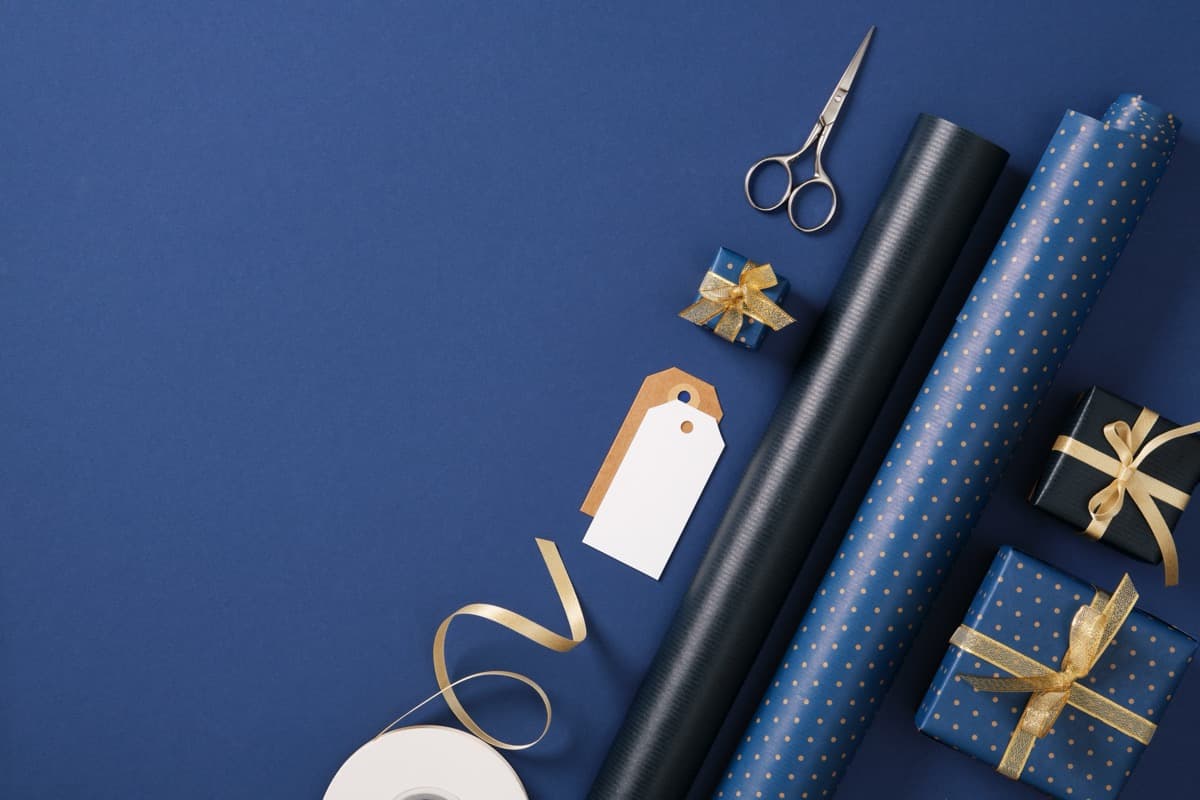 Gift wrapping supplies flat lay with ribbons scissors and paper