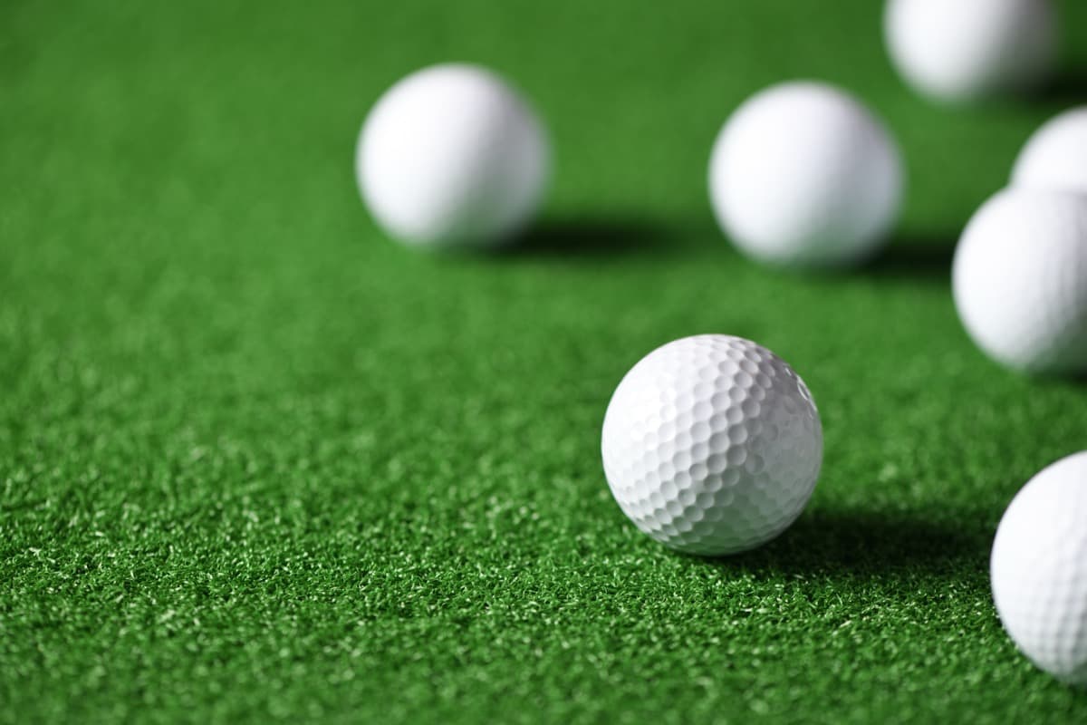 White golf balls scattered across a green putting surface