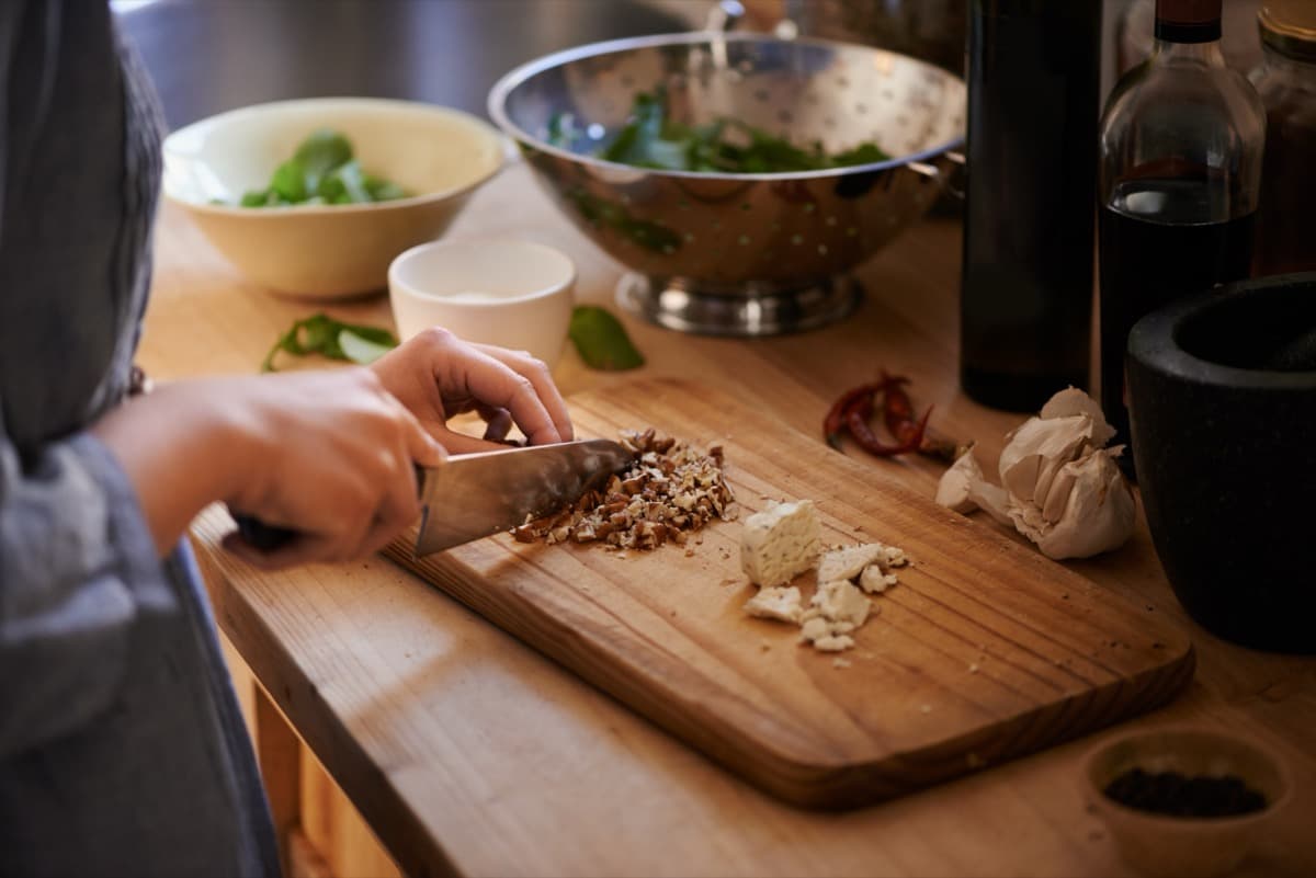 Fresh vegetables on wooden chopping board in modern kitchen
