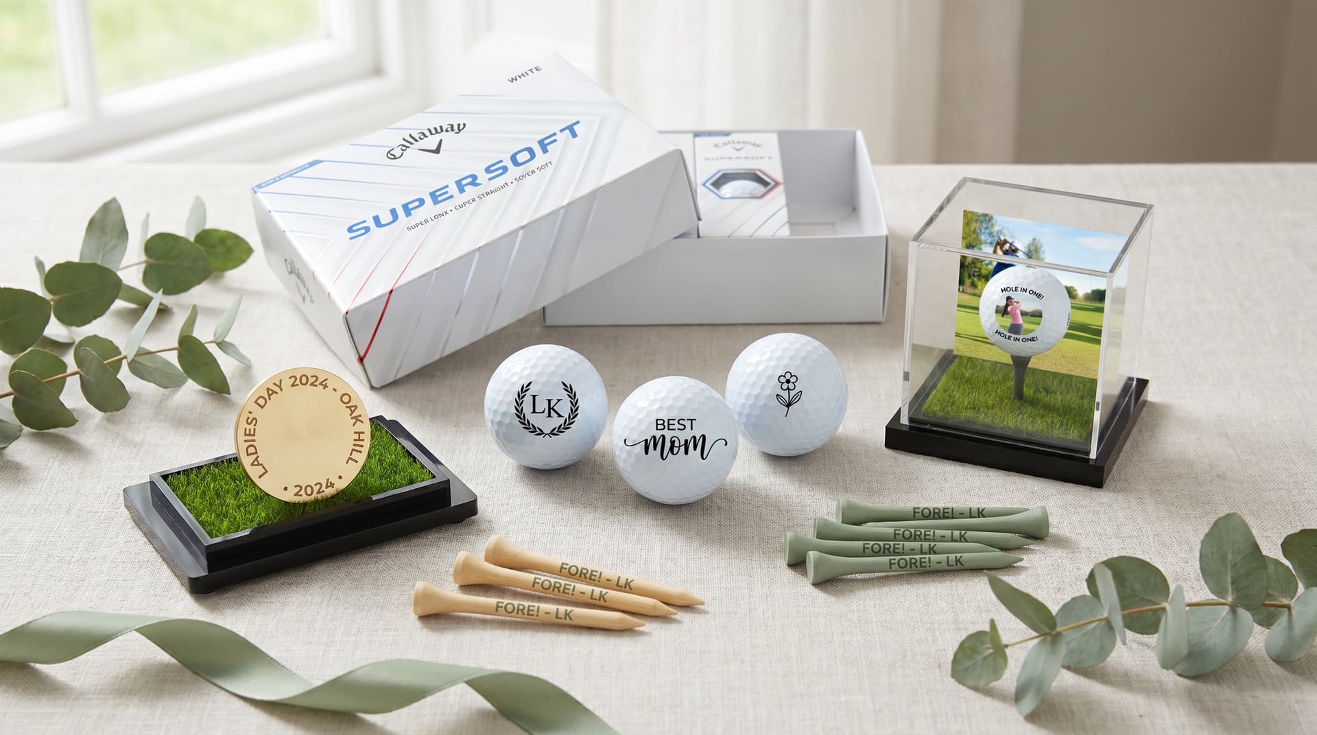 Personalised Callaway golf balls and engraved accessories arranged as a golf gift for her