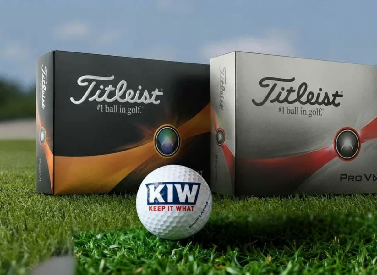 Titleist Pro V1 and Pro V1x boxes with KIW personalised golf ball on green grass