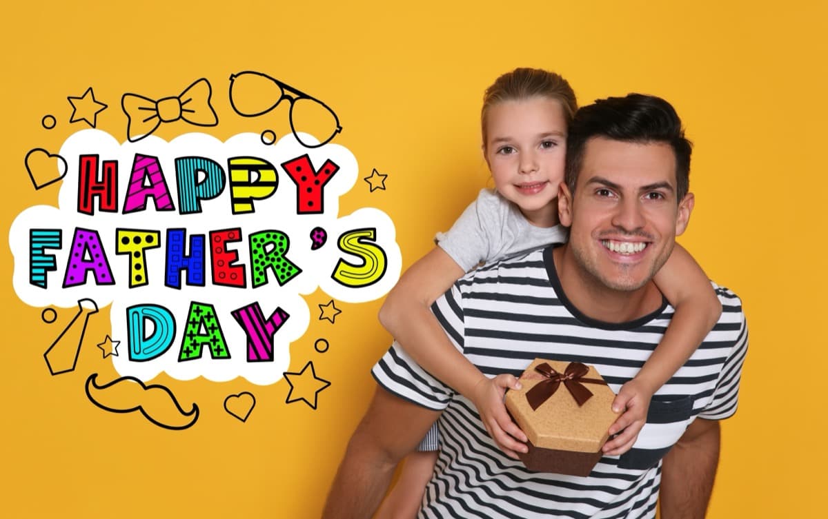 Happy dad with daughter on his back holding Father's Day gift