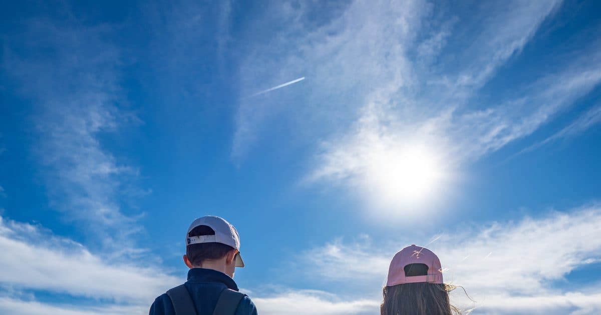 Two junior golfers walking down a fairway carrying Upswing junior golf bags