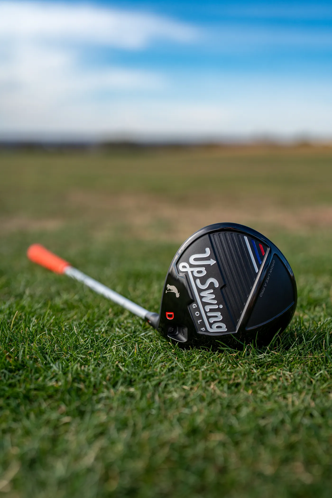 Upswing junior driver resting on the fairway, showing the Grow Like A Pro crown detail